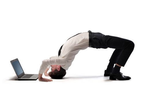man looking at his laptop upside down