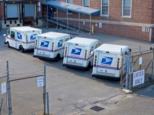 Postal vehicles parked in post office lot at Haverhill Massachusetts, September 2022. A typical busy post office lot where trucks load and unload postal mail distributed around the world.