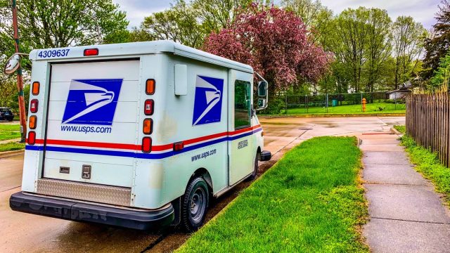 US Postal Service truck or in another name is LLV (Long life vehicle) park by the side of the road after the rain