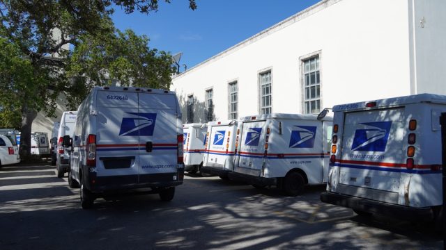 A row of USPS trucks parked to the rear of the south beach post office