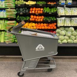 Product image of an Albertson's smart shopping cart made by Veeve in front of a produce display