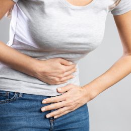 Young woman having painful stomach ache. Chronic gastritis. Stomach or menstrual cramps. Abdomen bloating concept.