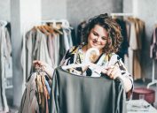 A smiling woman shops in a store for plus size clothing