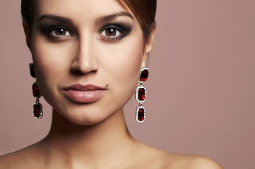 Close up of a beautiful woman wearing three-tiered ruby earrings