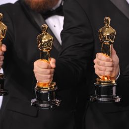 Men holding Oscar statuettes