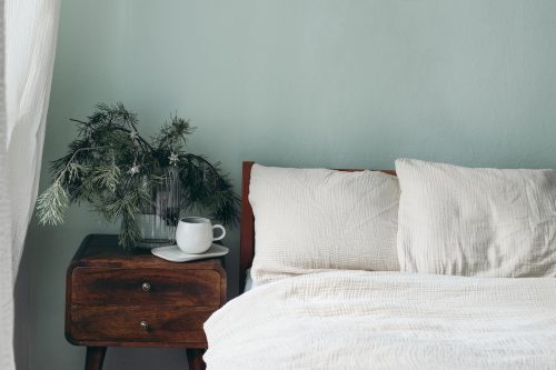 Trải giường bằng ga trải giường màu trắng trên những bức tường màu xanh lá cây nhạt