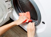Photo of woman hands wiping cloth washing machine