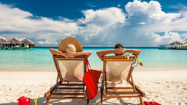 Couple in loungers on a tropical beach at Maldives