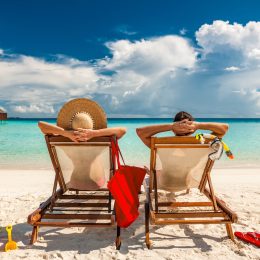 Couple in loungers on a tropical beach at Maldives
