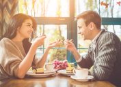 Một cặp đôi hẹn hò ăn bánh trong một quán cà phê đầy nắng