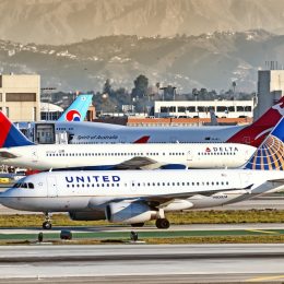 A United plane and Delta plane on the runway at a busy airport