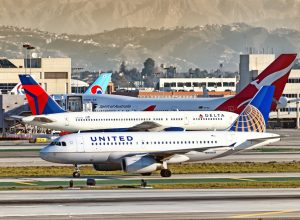 A United plane and Delta plane on the runway at a busy airport