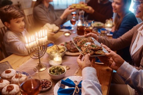 close up of family passing food around the table during Hanukkah