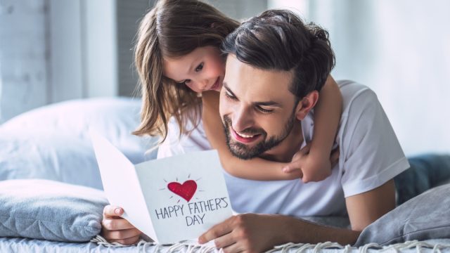 little her hugs her dad on father's day while he opens his card