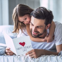 little her hugs her dad on father's day while he opens his card