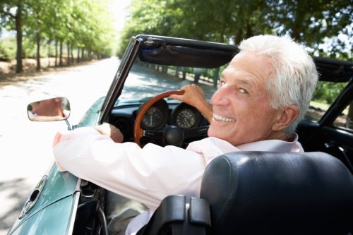 older man driving a sports car