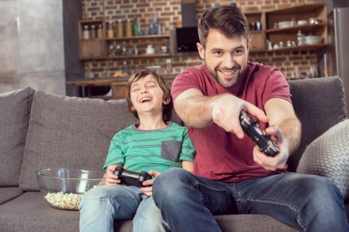father and son playing video games together