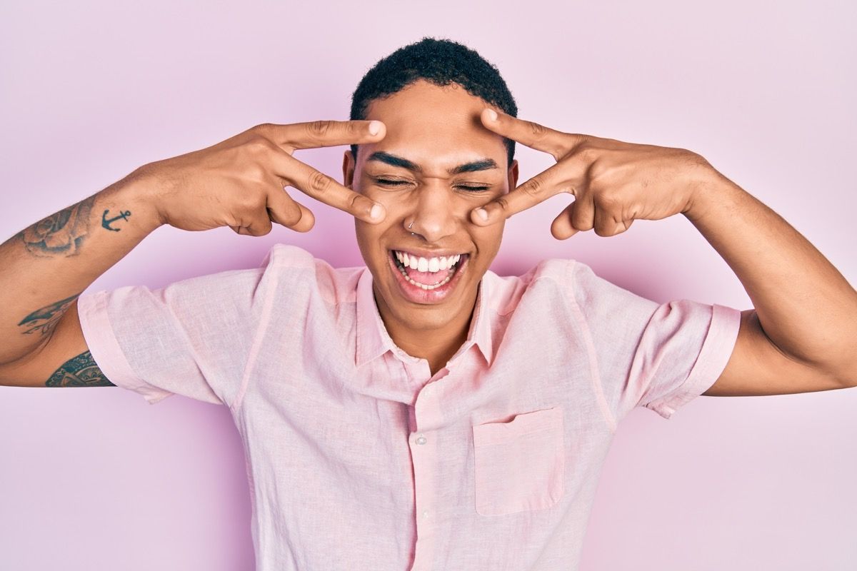 man doing a victory sign after making his friends laugh with a funny pun