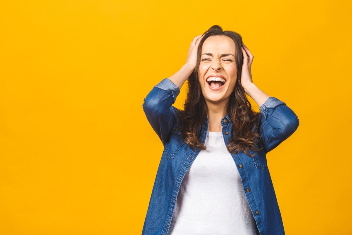 woman putting her fingers through her hair while laughing hysterically