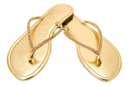 A pair of ladies gold flip flops with diamonds in the straps