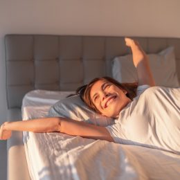 happy woman waking up in the morning light