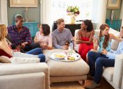 Group Of Friends Relaxing At Home In Living Room With Drinks Together