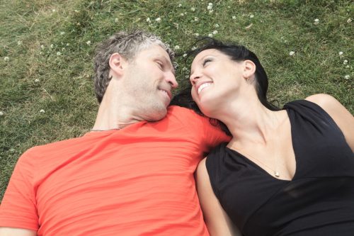 couple laughing in the grass together