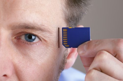 man holding a computer chip to his head