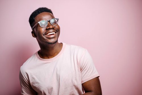 black man smiling on pink background