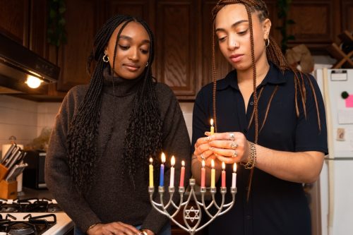 Women Lighting Candles on Menorah