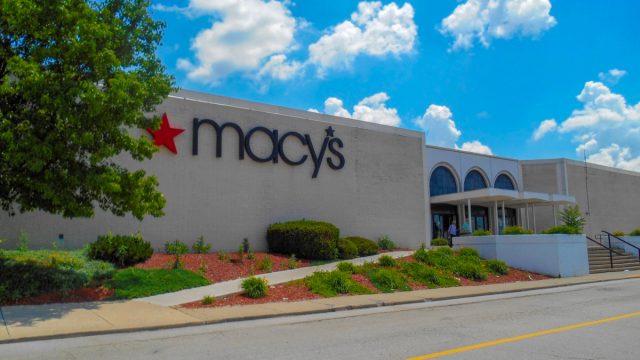 landscaping near entrance to retailer with corporate sign with star logo hanging on outside wall. Cincinnati based Macy’s department stores operates over 660 locations in the United States and is a common anchor tenant at many suburban malls.