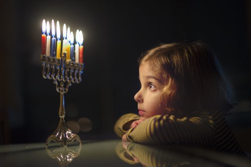Child Looking at Menorah Candles