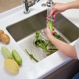 Food waste disposer machine in sink in modern kitchen