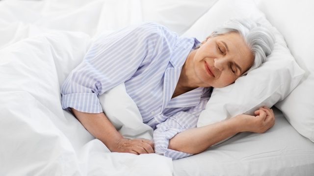 old age and people concept - senior woman sleeping in bed at home bedroom