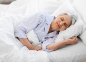 người già và khái niệm người già - người phụ nữ lớn tuổi ngủ trên giường trong phòng ngủ tại nhà