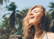 woman smiling in the sunshine while repeating positive affirmations