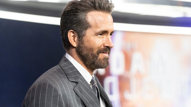 Side view of Ryan Reynolds in a gray pinstripe suit