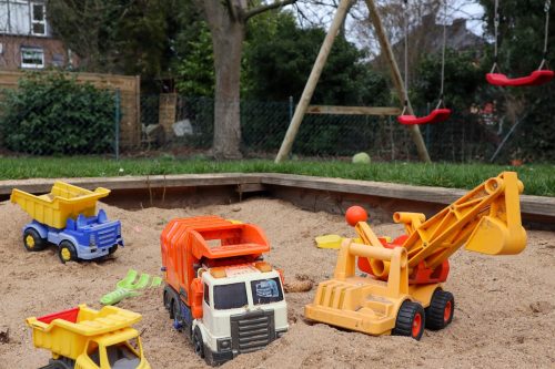 A backyard sand pit filled with toys