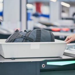 traveler putting bag through airport security