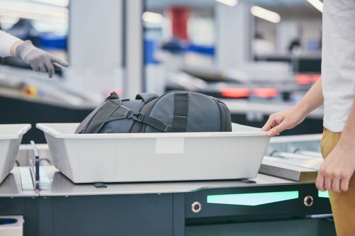 traveler putting bag through airport security