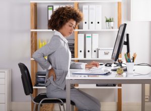 Young Businesswoman Suffering From Back Pain While Working In Office