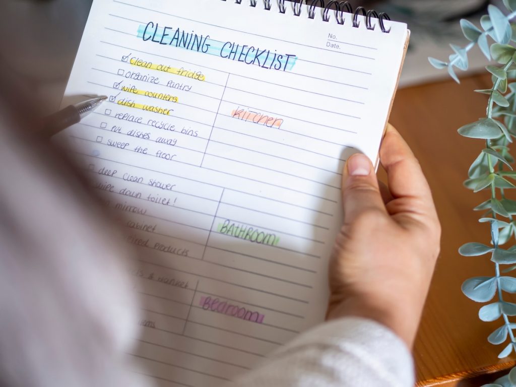 person holding a spring cleaning checklist