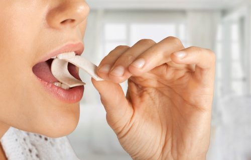 close up of woman putting gum in her mouth