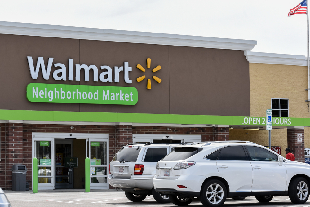 A Walmart Neighborhood Market storefront with cars parked in front