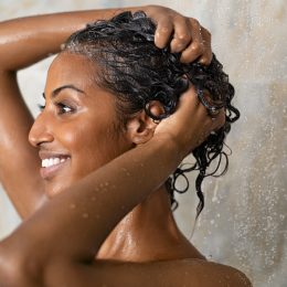 Woman,Washing,Hair,Showering,In,Bathroom,At,Home.,Smiling,Black