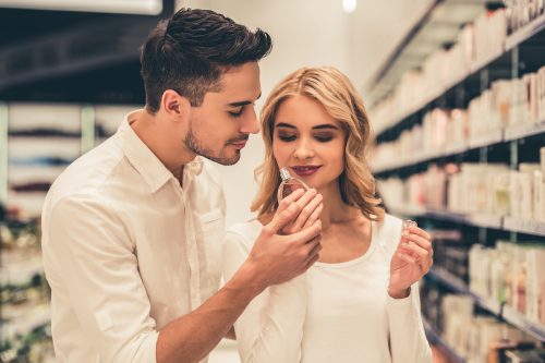 A young couple smells a perfume in a store