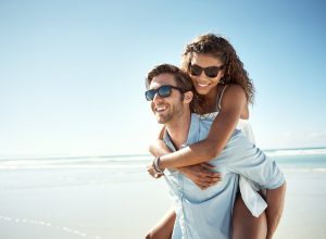 Couple on a beach in sunglasses smiling