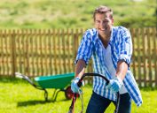 người đàn ông hạnh phúc cắt cỏ trong vườn nhà