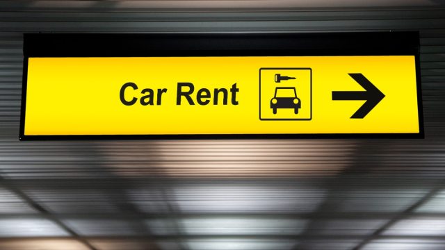Car rental sign directing airline passengers to car rental services.