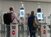 Passengers completing facial recognition at airport security checkpoint.